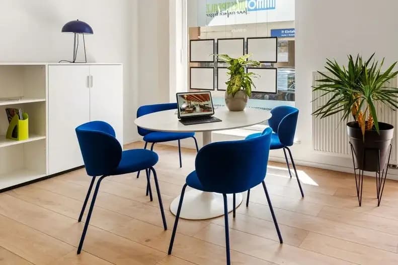 Finanzierung — heller Beratungsraum mit blauen Stühlen, Laptop und Schaufenster-Auslagen Finanzierung — heller Beratungsraum mit blauen Stühlen, Laptop und Schaufenster-Auslagen